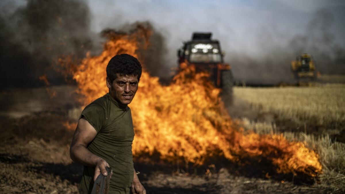 People battle a blaze next to an oil well in an agricultural field in the town of al-Qahtaniyah, in the Hasakeh province near the Syrian-Turkish border on June 10, 2019. Fires have erupted in various parts of Syria in recent weeks, with all sides blaming each other for starting them. Delil souleiman / AFP