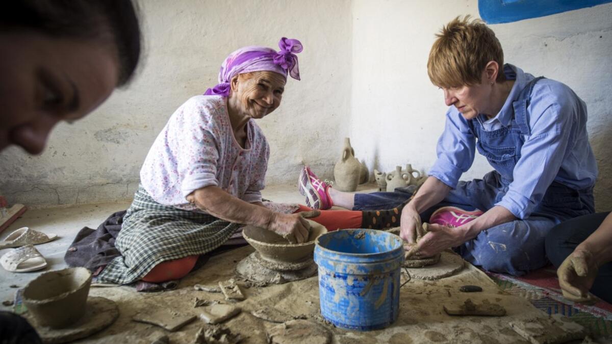 Moroccan potter Aicha Tabiz (L), also known as Mama Aicha, sits next to British apprentice Kim West (R), 33, during a pottery workshop near the village of Ourtzagh in the foothills of the Rif mountains on June 12, 2019. FADEL SENNA / AFP