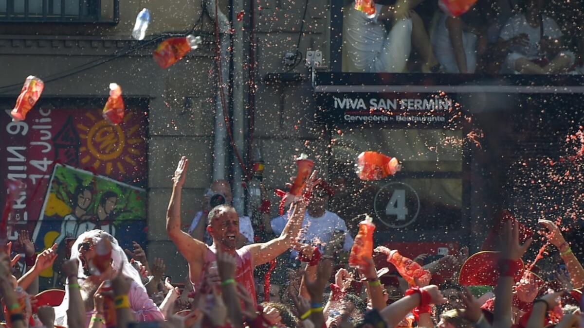 Revellers celebrate during the 'Chupinazo' (start rocket) to mark the kickoff at noon sharp of the San Fermin Festival, in front of the Town Hall of Pamplona, northern Spain, on July 6, 2019.  PIERRE-PHILIPPE MARCOU / AFP