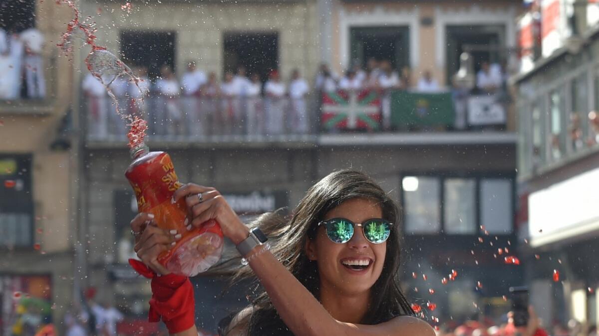 A reveller celebrates during the 'Chupinazo' (start rocket) to mark the kickoff at noon sharp of the San Fermin Festival, in front of the Town Hall of Pamplona, northern Spain, on July 6, 2019.  ANDER GILLENEA / AFP
