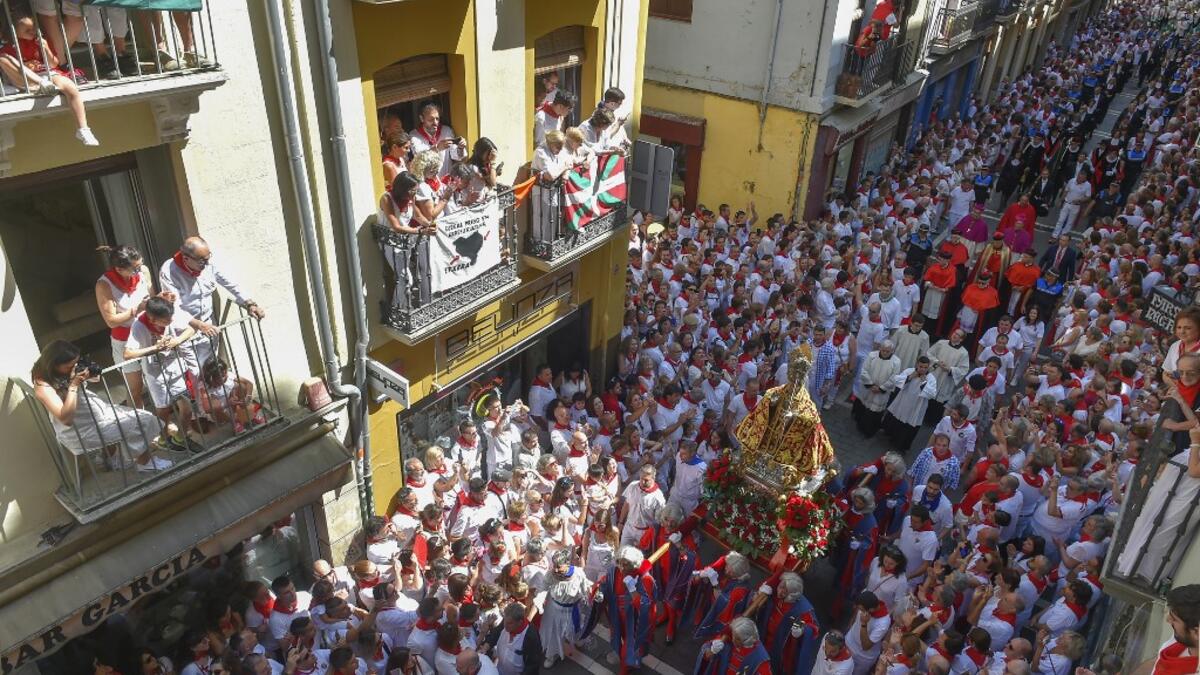 People look at the procession of Pamplona´s patron Saint Fermin on the first day of the San Fermin bullrun festival in Pamplona, northern Spain on July 7, 2019. ANDER GILLENEA / AFP