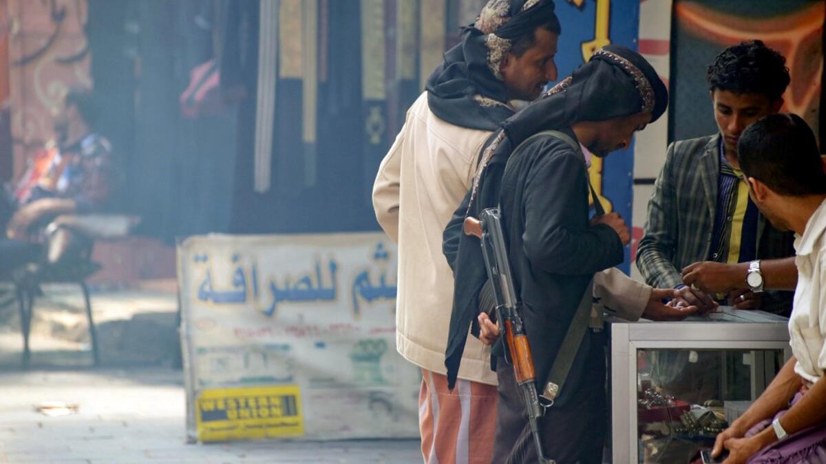Armed men shop in Yemen's third city of Taez, on July 13, 2019. Before the war, the old market of Taez was crowded with people and full of handcrafts and artisanal goods. AHMAD AL-BASHA / AFP