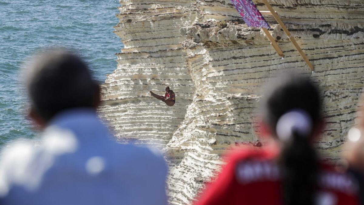 A cliff diver jumps from a platform on the landmark Raouche sea rock off the coast of the Lebanese capital Beirut on July 14, 2019, during the women's 2019 Red Bull Cliff Diving World Series.  ANWAR AMRO / AA / AFP