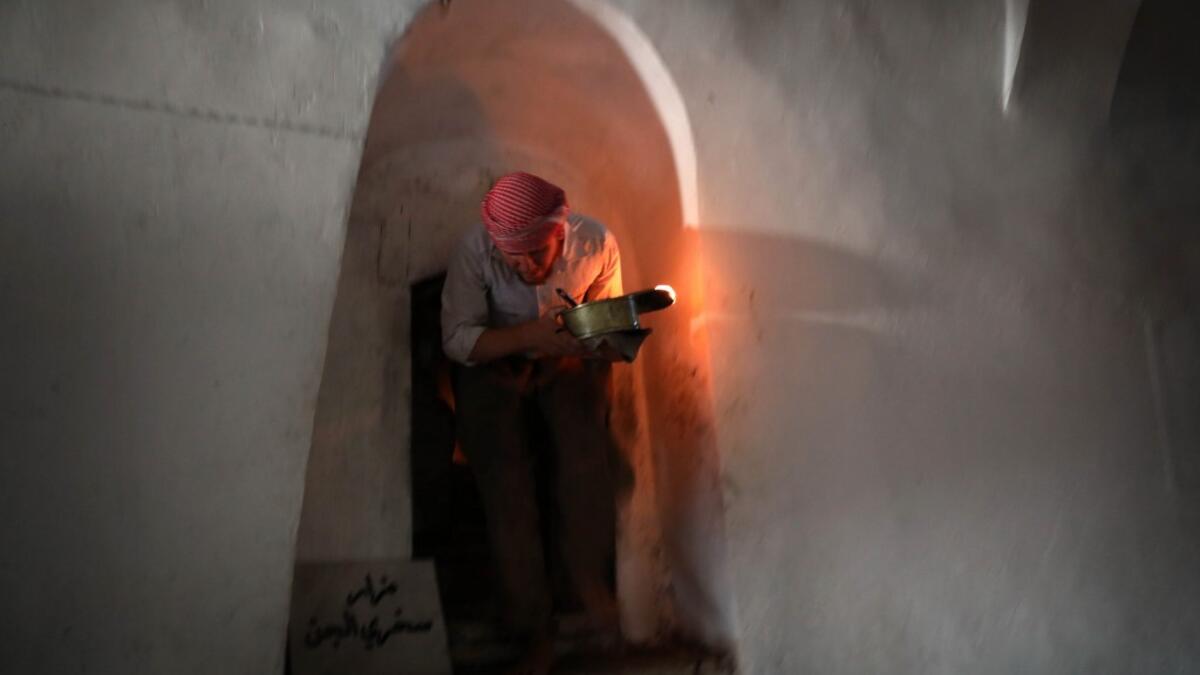 An Iraqi Yezidi visits the Temple of Lalish, in a valley near the Kurdish city of Dohuk about 430km northwest of the capital Baghdad, on July 16, 2019. Of the 550,000 Yazidis in Iraq before the Islamic State (IS) group invaded their region in 2014, around 100,000 have emigrated abroad and 360,000 remain internally displaced. Roughly 3,300 Yazidis have returned from IS captivity in the last five years, only 10 percent of them men. SAFIN HAMED / AFP
