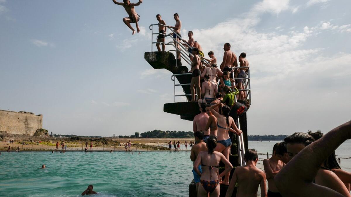 People queue to dive into the landmark sea pool of Saint-Malo, Brittany, on July 23, 2019 as a new heatwave blasted into northern Europe that could set records in several countries. Valery HACHE / AFP