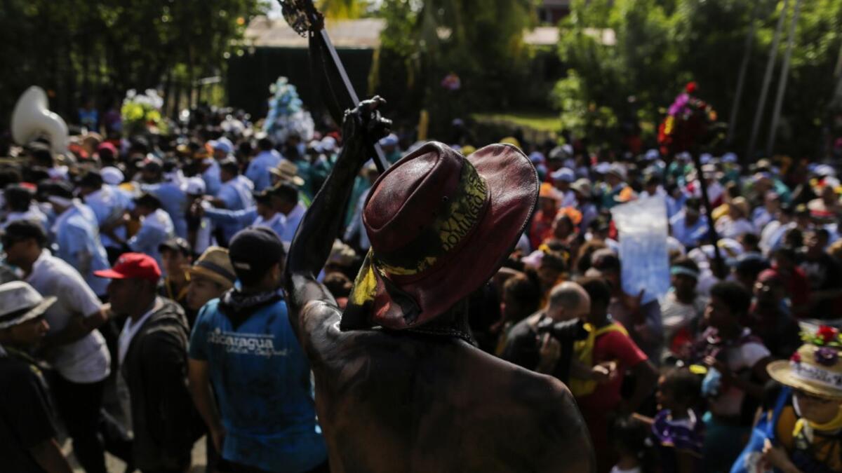 Catholic faithful smeared in burnt oil, take part in the opening of the ten-day celebration of the Santo Domingo de Guzman festival in Managua, on August 1, 2019.  INTI OCON / AFP