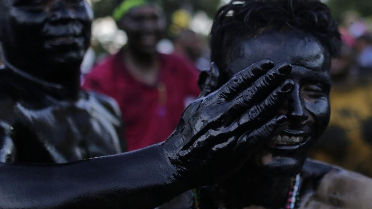 Catholic faithful smeared in burnt oil, take part in the opening of the ten-day celebration of the Santo Domingo de Guzman festival in Managua, on August 1, 2019.  INTI OCON / AFP