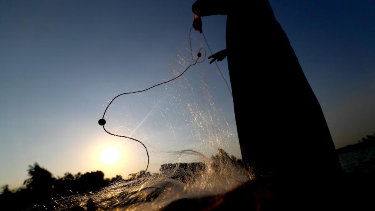 An Egyptian Fisherman holds a fishing net on the waters of the Pharaonic Sea in the village of Kafr Fisha, province of Monufia, on August 13, 2019. Mohamed el-Shahed / AFP