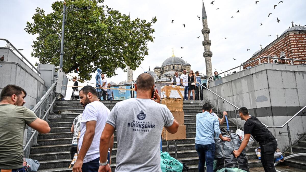 Shop owners try to save their belongings in a flooded undergate shop center in Eminonu district, Istanbul, after a heavy rainfall, on August 17, 2019. Turkey's mega city Istanbul was lashed by a heavy rainstorm on August 17, killing a homeless man and leaving parts of the historic Grand Bazaar flooded.  Ozan KOSE / AFP