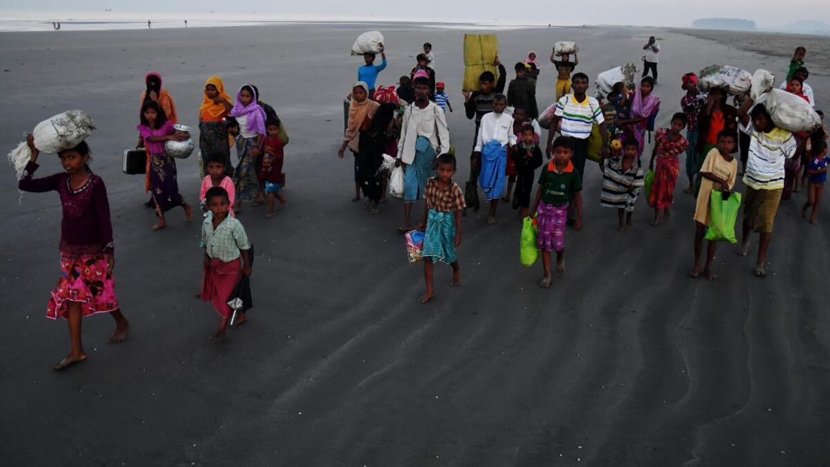 Rohingya Muslim refugees who entered Bangladesh by boat walk towards refugee camps after landing at the Saplapur beach in the Teknaf district. When hundreds of thousands of Rohingya fled Myanmar into Bangladesh two years ago. Dibyangshu SARKAR / AFP