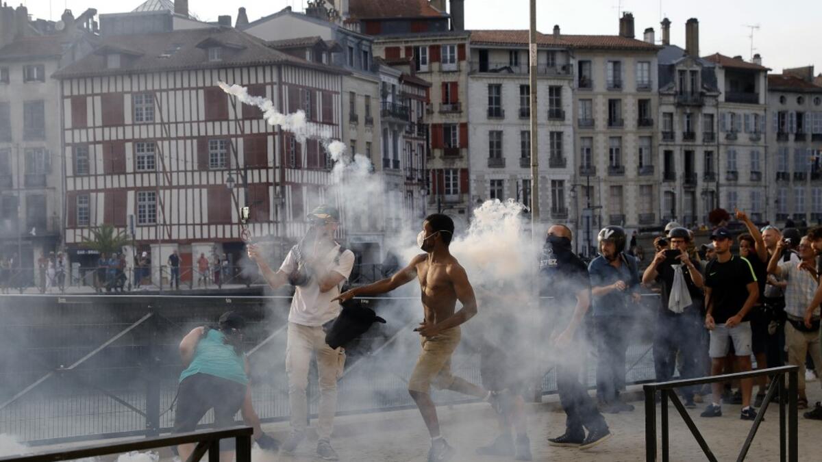 A protester lobs a 'canister' back towards French security personnel during a demonstration in the city of Bayonne, south-west France on August 24, 2019, on the sidelines of the annual G7 Summit. Thomas SAMSON / AFP