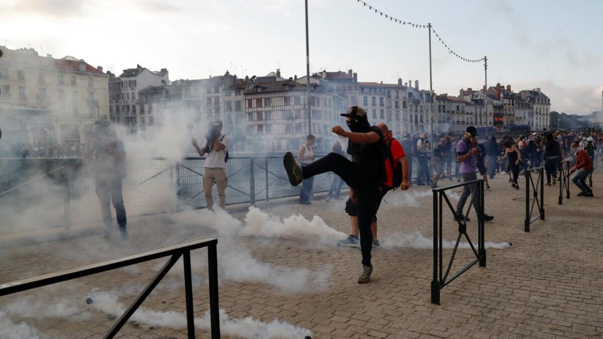 A protester kicks away a 'canister' fired by French security personnel during a demonstration in the city of Bayonne, south-west France on August 24, 2019. Thomas SAMSON / AFP