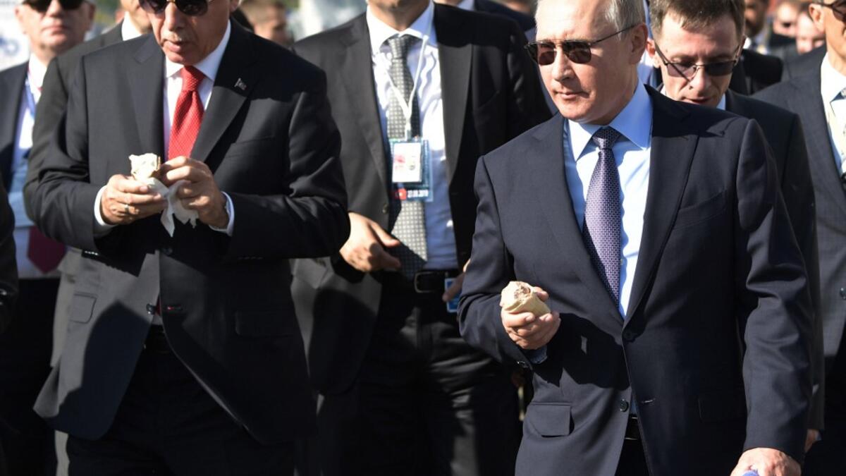 Russian President Vladimir Putin (R) and his Turkish counterpart Recep Tayyip Erdogan eat loacally made ice cream as they visit the MAKS-2019 International Aviation and Space Salon opening day in Zhukovsky outside Moscow on August 27, 2019.  Alexey NIKOLSKY / SPUTNIK / AFP