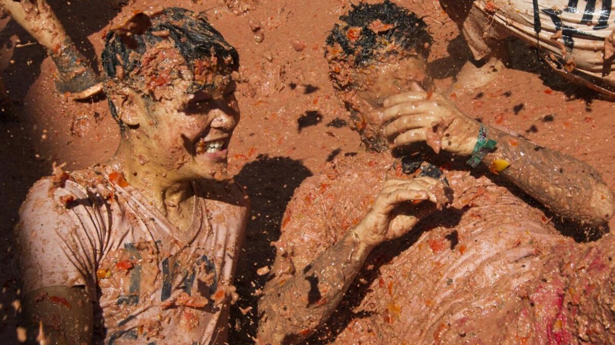 A reveller covered in tomato pulp participates in the annual "Tomatina" festival in the eastern town of Bunol, on August 28, 2019. JAIME REINA / AFP