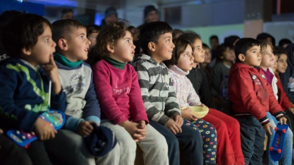 Children attend a film screening as part of the mobile cinema "Komina Film" initiative organised by Syrian-Kurdish filmmaker Shero Hinde, at a school yard in the village of Shaghir Bazar, 55 kilometres southest of Qamishli in the Kurdish-populated areas of northeastern Syria's Hasakeh province, on July 28, 2019. (Twitter)