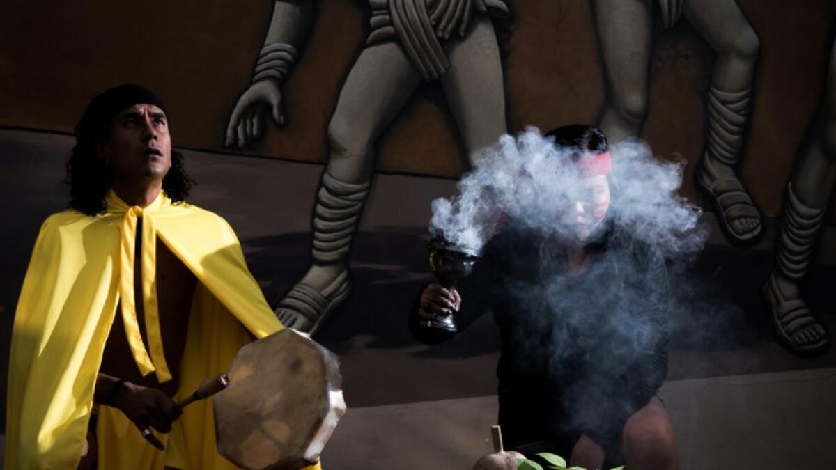 Master Emmanuel Galicia (L) and dancer Beatriz Campos (R) perform ahead of a pre-Columbian ballgame called "Ulama" -in Nahuatl indigenous language- which rule is to hit a "Ulamaloni" (solid rubber ball) with the hip or shoulder, at the FARO Poniente cultural center in Mexico City on August 21, 2019. Omar Torres / AFP