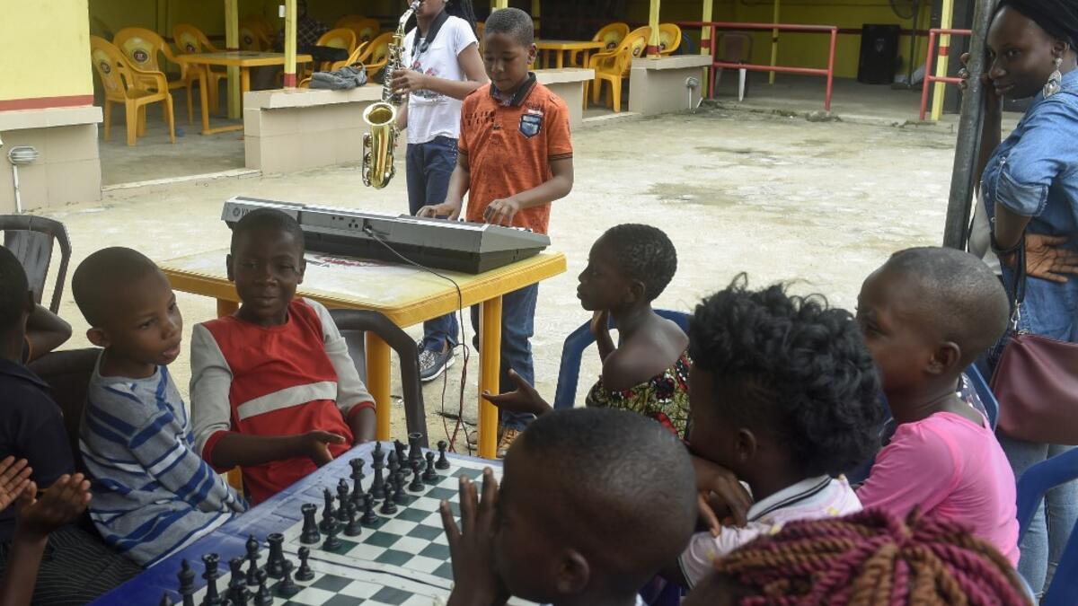 Young saxophonist Temilayo Abodurin (L) and pianist Joshua Akinotan play to motivate fellow children during a chess class at Ogolonto in Ikorodu district of Lagos, on August 17, 2019.  PIUS UTOMI EKPEI / AFP