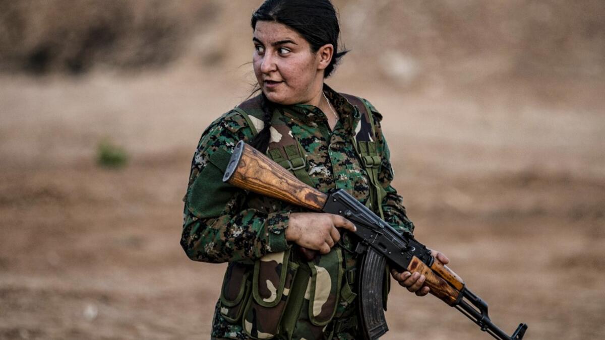 A member of the Bethnahrin Women Protection Forces (HSNB), an all-female Syriac-Assyrian paramilitary group under the umbrella of the Syrian Democratic Forces (SDF), lines up as the group commemorates the fourth anniversary of its creation, in the countryside of the town of Tall Tamr in the northwestern Syrian province of Hasakah, on August 30, 2019.  Delil SOULEIMAN / AFP