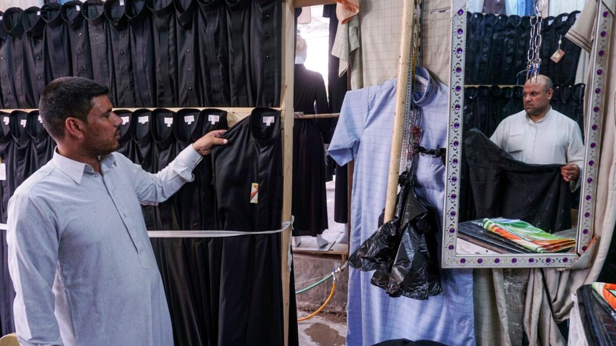 A man browses black garbs sold to Shiite Muslim pilgrims amidst preparations ahead of the Shiite religious mourning period of Ashura, in the central Iraqi holy shrine city of Najaf on August 31, 2019.  Haidar HAMDANI / AFP