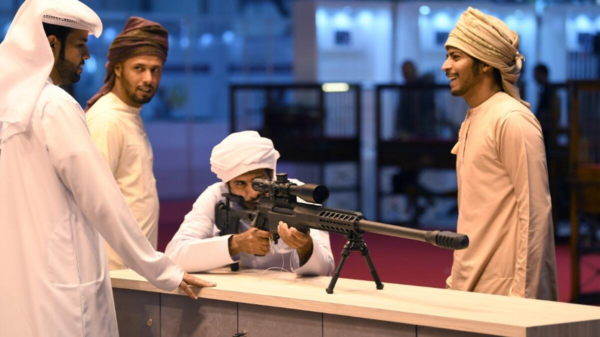 A visitor inspects a sniper rifle during the Abu Dhabi International Hunting and Equestrian exhibition (ADIHEX) in the UAE capital Abu Dhabi on August 31, 2019.  KARIM SAHIB / AFP