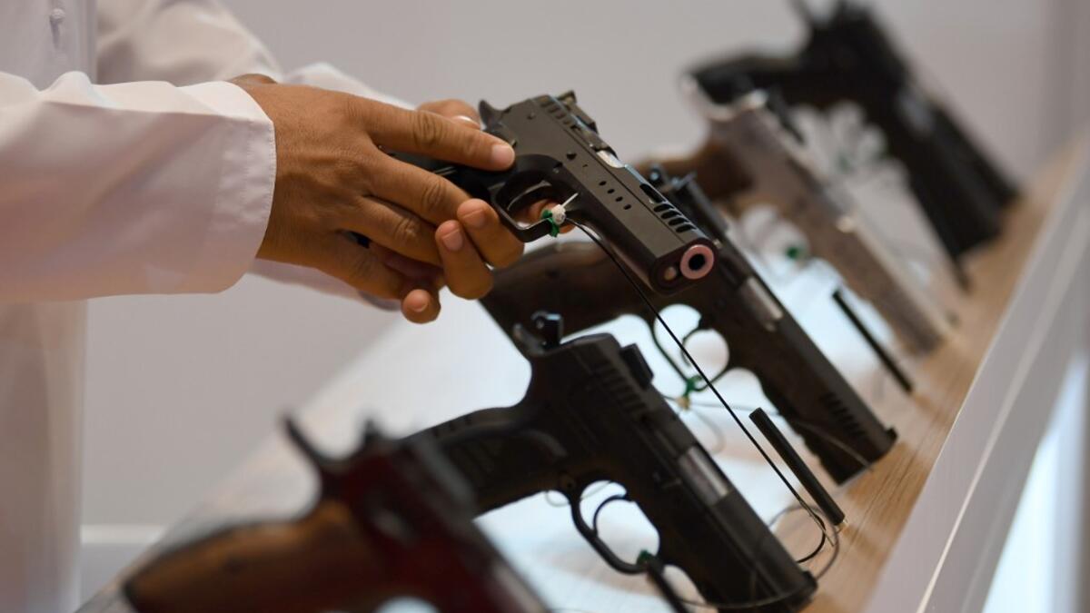 A visitor inspects a pistol gun during the Abu Dhabi International Hunting and Equestrian exhibition (ADIHEX) in the UAE capital Abu Dhabi on August 31, 2019.  KARIM SAHIB / AFP