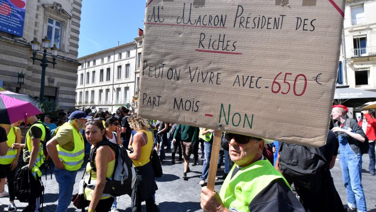 A protester holds a placard reading "Mr Macron President of rich people. Can we live with 650 euros per month ? No" during an anti-government demonstration called by the "Yellow Vests" (Gilets Jaunes) movement on September 7, 2019 in Montpellier, southern France. Pascal GUYOT / AFP