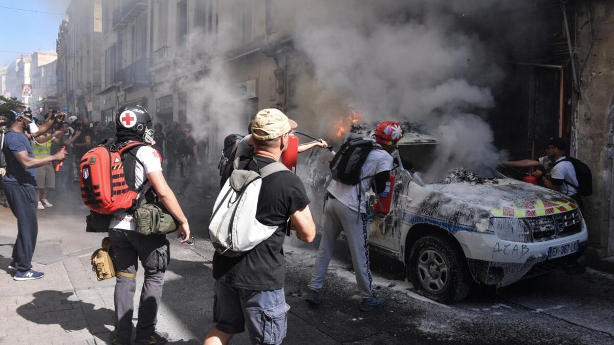 Street medics use a fire extinguishers on a burning French Municipal Police car on the sidelines of an anti-government demonstration called by the "Yellow Vests" (Gilets Jaunes) movement in Montpellier, southern France on September 7, 2019. Pascal GUYOT / AFP