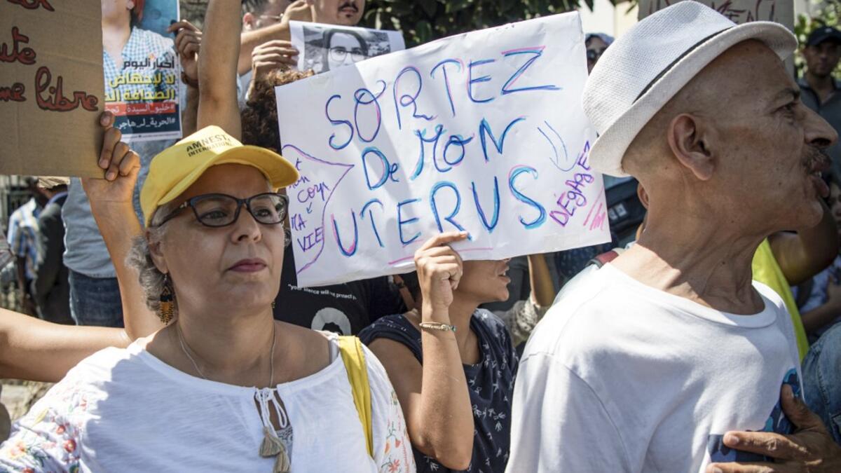 A demonstrator holds up a sign reading in French "get out of my uterus", during a protest outside a courthouse holding the trial of Hajar Raissouni, a Moroccan journalist of the daily newspaper Akhbar El-Youm, on charges of abortion, in the capital Rabat on September 9, 2019. FADEL SENNA / AFP