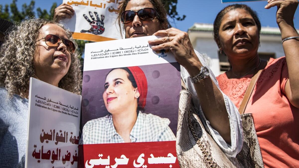 Demonstrators hold up a sign showing the portrait of Hajar Raissouni, a Morrocan journalist of the daily newspaper Akhbar El-Youm, with a caption below in Arabic reading "my body, my freedom", as they gather outside a courthouse holding her trial on charges of abortion in the capital Rabat on September 9, 2019. FADEL SENNA / AFP