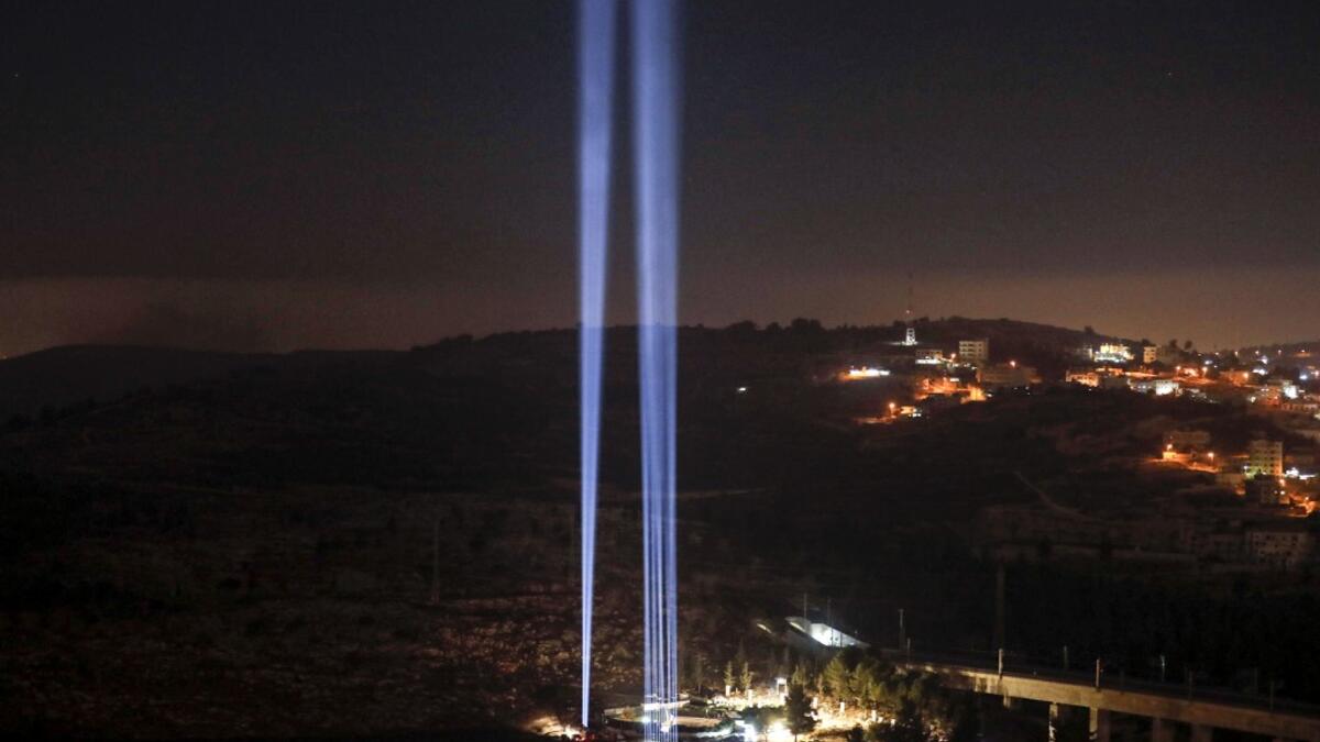 This picture shows a light show in tribute to New York City's World Trade Centre Twin Towers on the eve of the 18th anniversary of the September 11, 2001 terror attacks, at the 9/11 Living Memorial Plaza on a hill overlooking Jerusalem. AHMAD GHARABLI / AFP