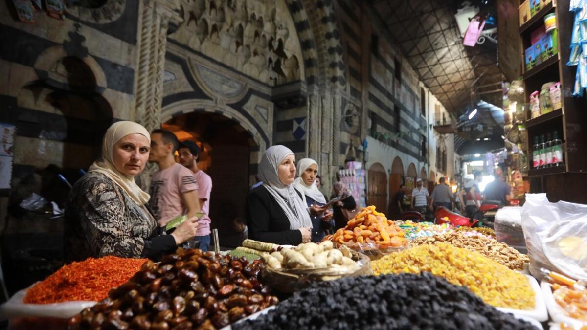 Women run errands at the Bzourieh market in the center of Damascus. LOUAI BESHARA / AFP