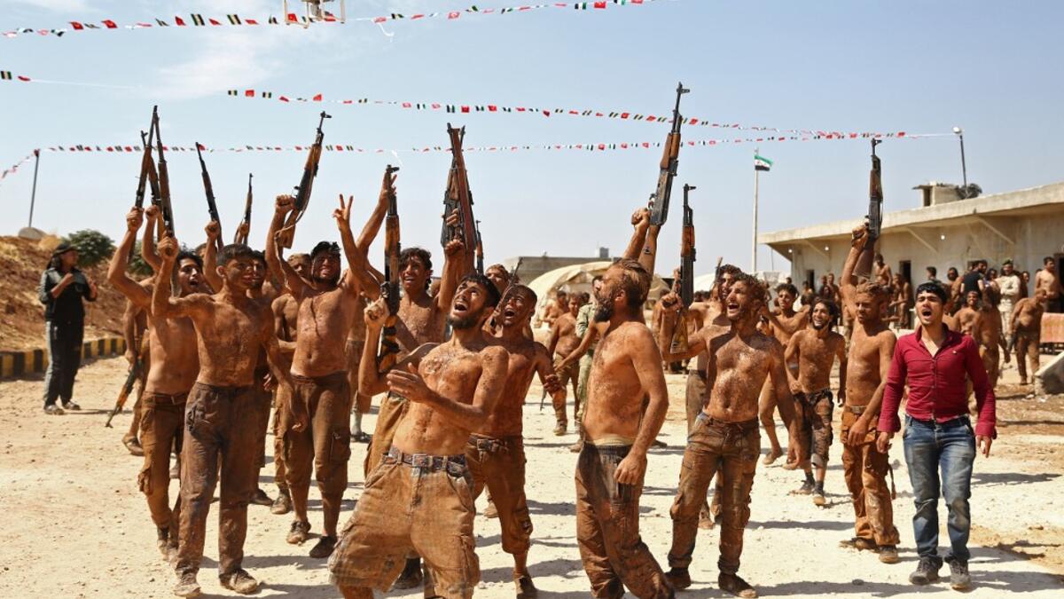Syrian Turkish-backed fighters from al-Mutasim Brigade react after finishing their training at a camp near the town of Marea in Syria's northern Aleppo district, on September 12, 2019. Nazeer Al-khatib / AFP