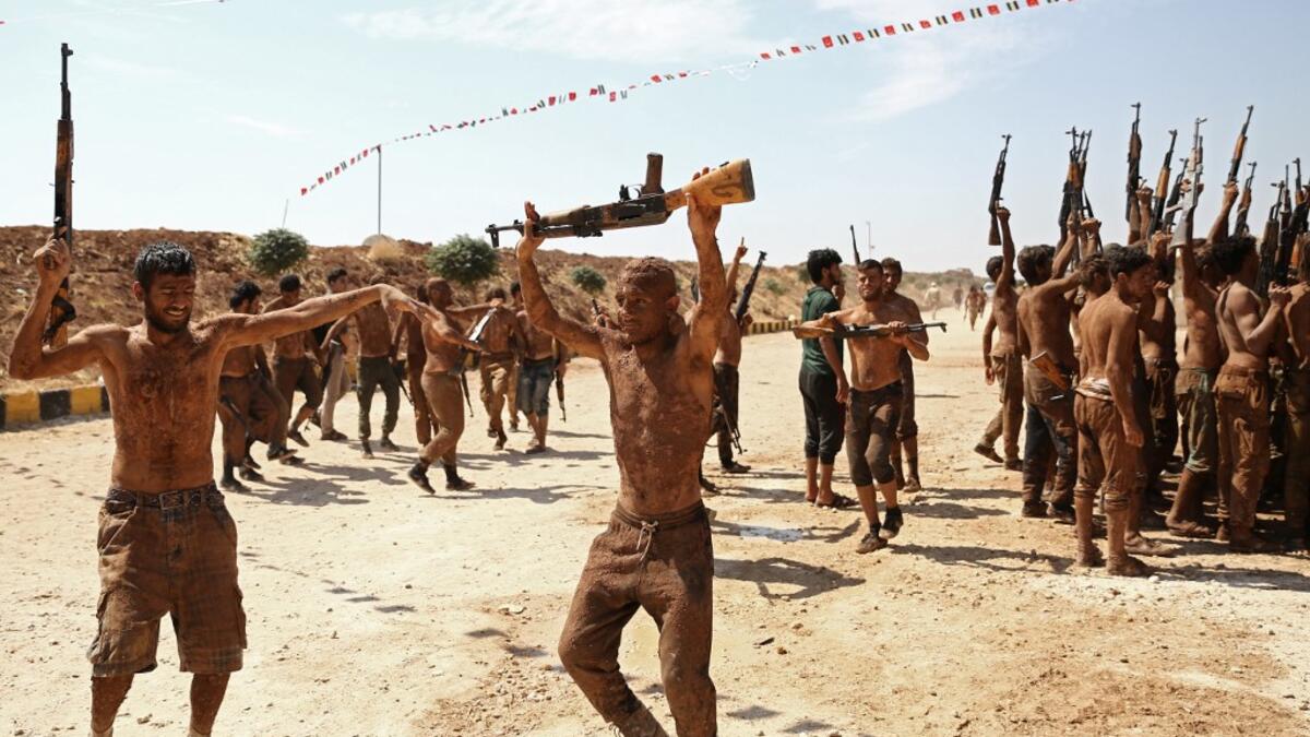 Syrian Turkish-backed fighters from al-Mutasim Brigade react after finishing their training at a camp near the town of Marea in Syria's northern Aleppo district, on September 12, 2019. Nazeer Al-khatib / AFP