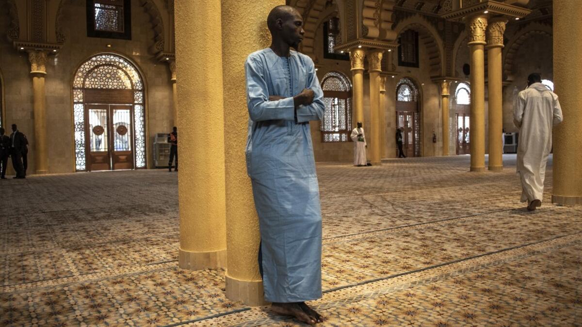 A worshipper stands inside the Great Mosque of the Mourides on September 27, 2019 in Dakar, ahead of its inauguration. Senegal's influential Mouride Brotherhood will inaugurate a 30,000-capacity mosque in the capital Dakar, said to be the largest in West Africa. JOHN WESSELS / AFP