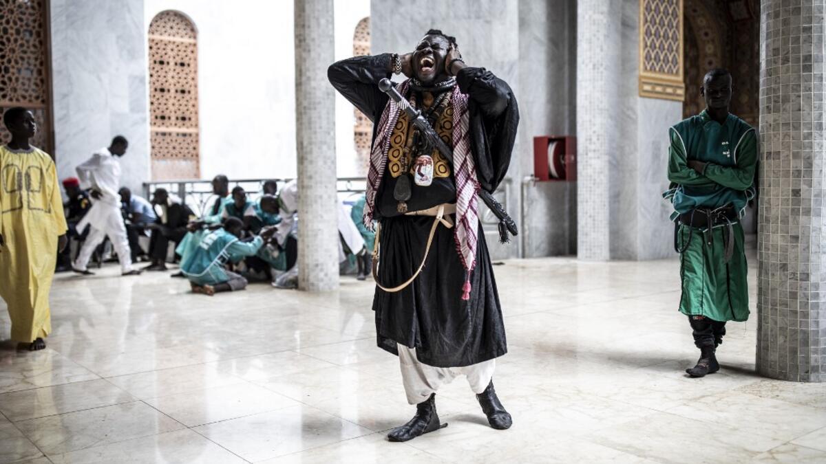 A Baye Fall disciple chants after entering the Great Mosque of the Mourides on September 27, 2019 in Dakar, ahead of its inauguration. Senegal's influential Mouride Brotherhood will inaugurate a 30,000-capacity mosque in the capital Dakar, said to be the largest in West Africa. JOHN WESSELS / AFP