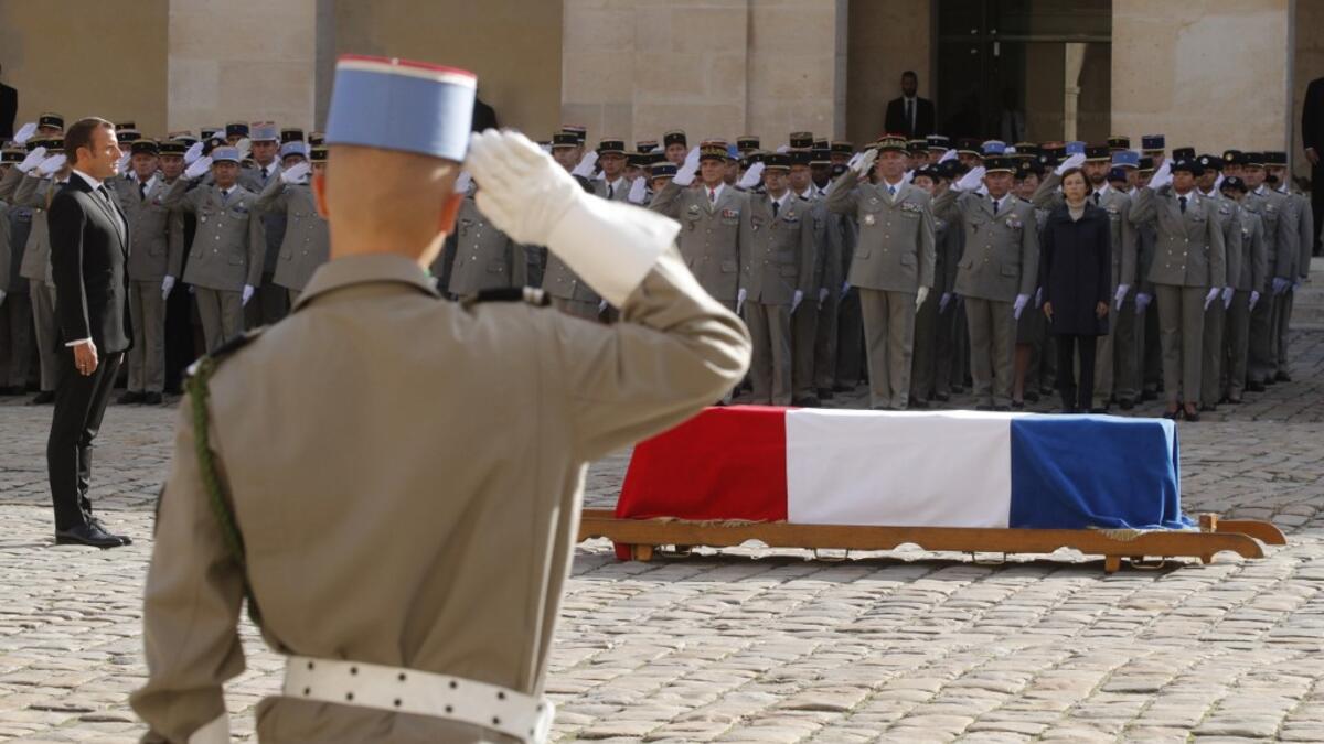 French President Emmanuel Macron (L) stands behind the flag-draped coffin of late French President Jacques Chirac during a military tribute at the Invalides (Hotel des Invalides) in Paris on September 30, 2019. Former French President Jacques Chirac died on September 26, 2019 at the age of 86. PHILIPPE WOJAZER / POOL / AFP