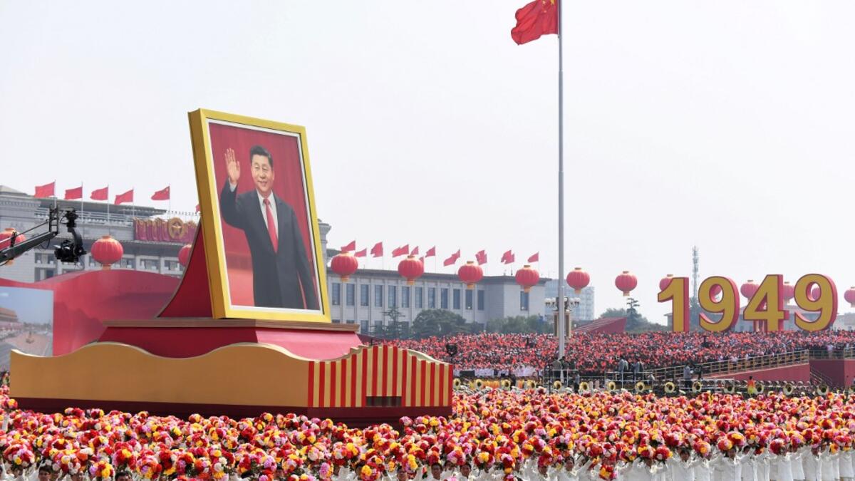 A float with a giant portrait of China's President Xi Jinping passes by Tiananmen Square during the National Day parade in Beijing on October 1, 2019, to mark the 70th anniversary of the founding of the People's Republic of China. GREG BAKER / AFP