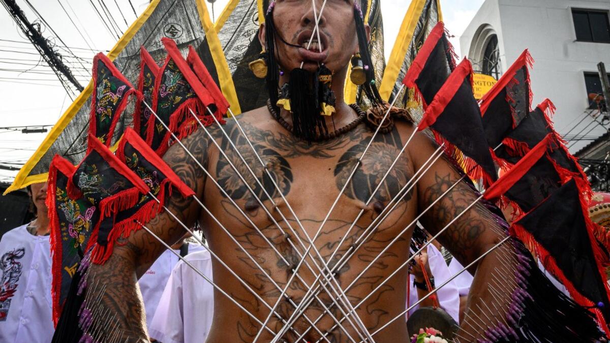 A devotee of a Chinese shrine with multiple needles pierced through his cheeks takes part in a procession during the annual Vegetarian Festival in Phuket on October 4, 2019. Mladen ANTONOV / AFP