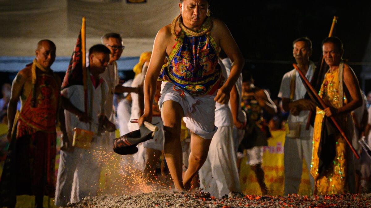 A devotee of a Chinese shrine walks on ambers during the annual Vegetarian Festival in Phuket on October 4, 2019.Mladen ANTONOV / AFP