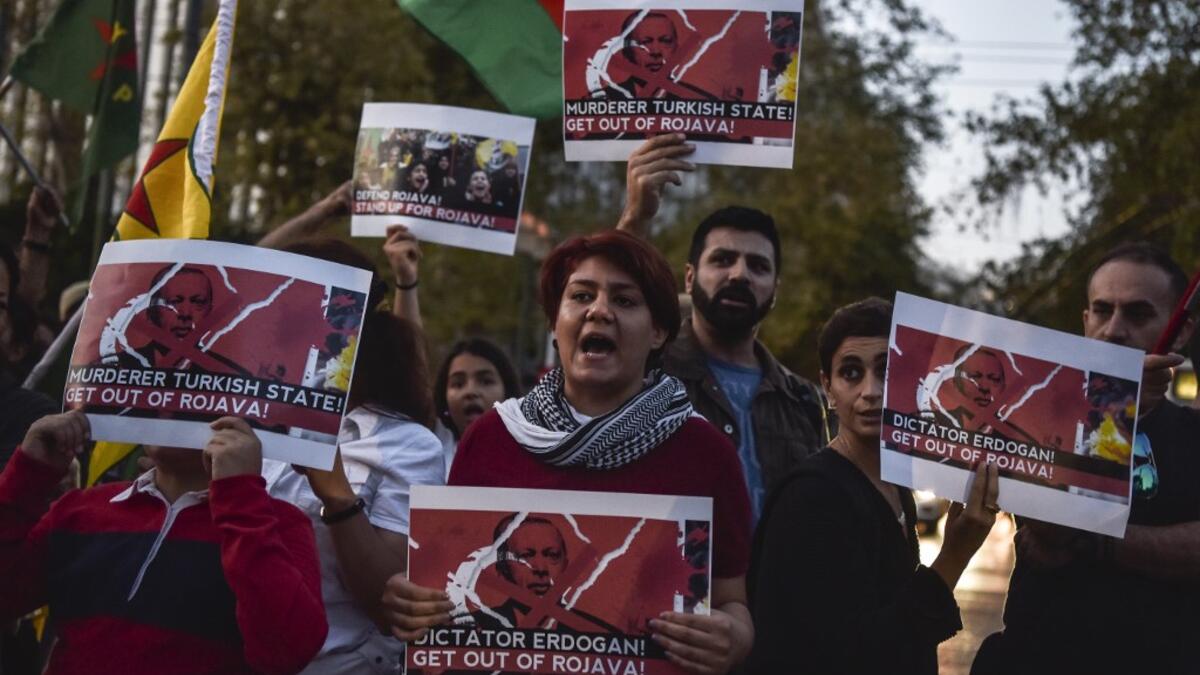 Kurds living in Athens hold banners as they protest near the Turkish embassy in Athens, on October 9, 2019. Turkey launched an assault on Kurdish forces in northern Syria with air strikes and explosions reported along the border. President Recep Tayyip Erdogan announced the start of the attack on Twitter, labelling it "Operation Peace Spring". Louisa GOULIAMAKI / AFP