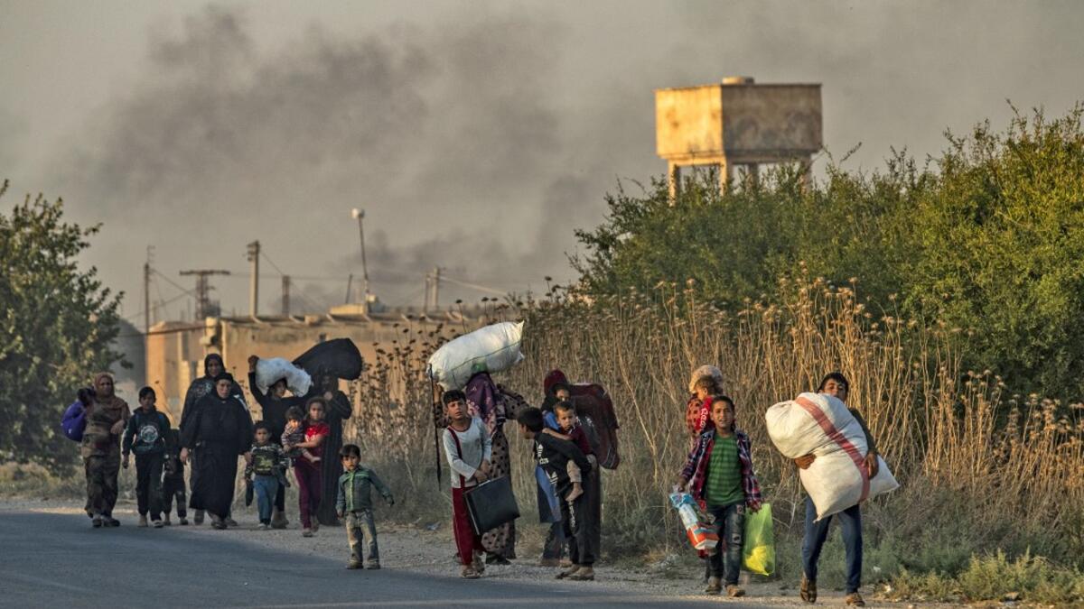 Civilians flee with their belongings amid Turkish bombardment on Syria's northeastern town of Ras al-Ain in the Hasakeh province along the Turkish border on October 9, 2019. Turkey launched a broad assault on Kurdish-controlled areas in northeastern Syria today, with intensive bombardment paving the way for an invasion made possible by the withdrawal of US troops. Delil SOULEIMAN / AFP