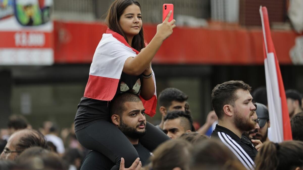 Lebanese demonstrators gather during a protest against dire economic conditions in Zouk Mikael, north of the Lebanese capital Beirut, on October 18, 2019. Public anger has simmered since parliament passed an austerity budget in July to help trim a ballooning deficit and flared on Thursday over new plans to tax calls on messaging applications such as Whatsapp, forcing the government to axe the unpopular proposal. JOSEPH EID / AFP