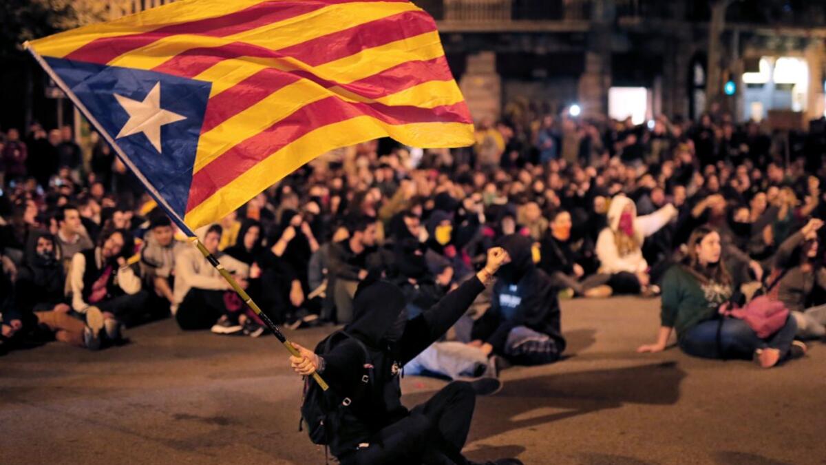 A protester waves a Catalan pro-independence "Estelada" flag during a protest outside the Spanish Government regional office in Barcelona on October 21, 2019. PAU BARRENA / AFP