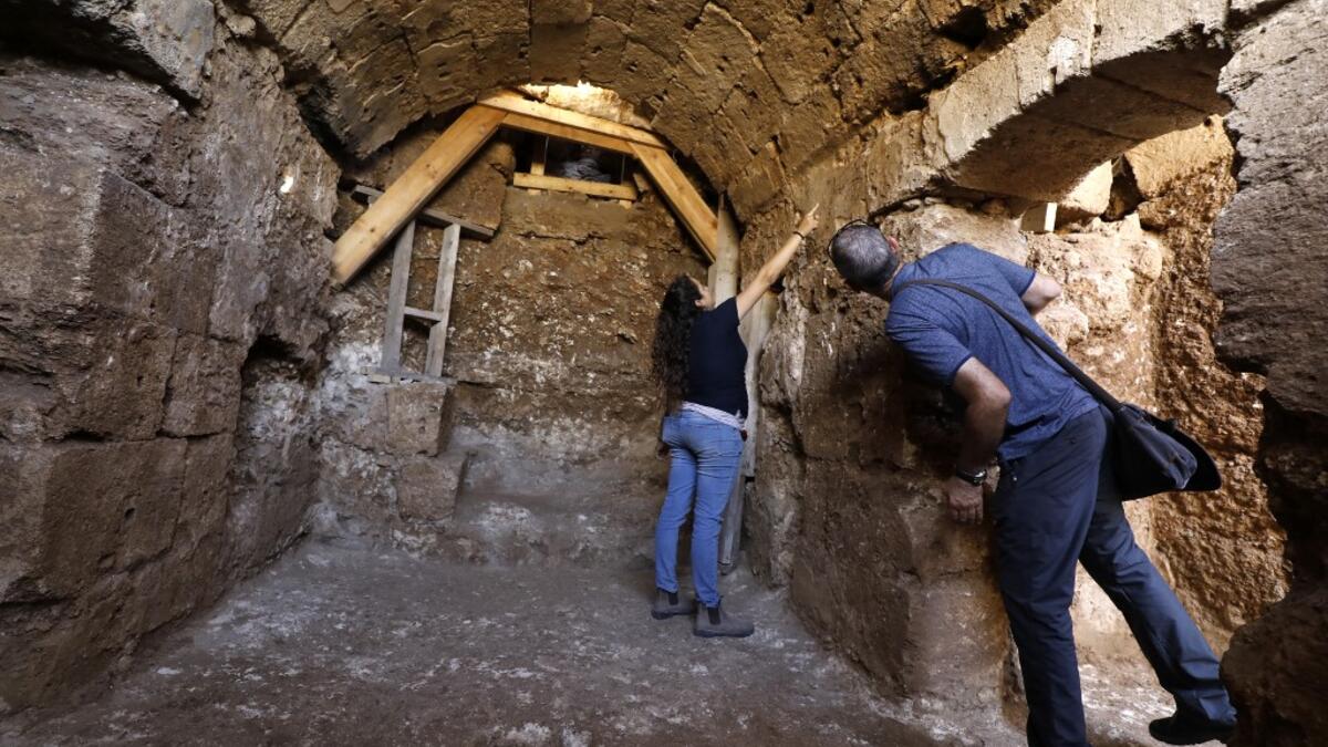 Timnah Goloubin (L), an archaeologist with the Israel Antiquities Authority, shows on October 23, 2019 the ancient church crypt in the Israeli city of Bet Shemesh. A magnificent 1500-year-old church, decorated with spectacular mosaic floors and Greek inscriptions, was discovered during a three-year excavation near a residential area. MENAHEM KAHANA / afp