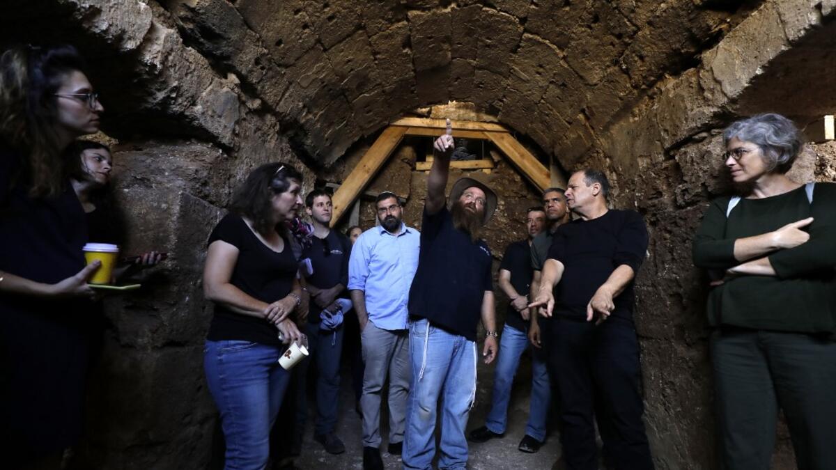 Binyamin Storchan (C), an archaeologist with the Israel Antiquities Authority, shows on October 23 2019 an ancient church crypt in the Israeli city of Bet Shemesh. A magnificent 1500-year-old church, decorated with spectacular mosaic floors and Greek inscriptions, was discovered during a three-year excavation near a residential area. MENAHEM KAHANA / afp