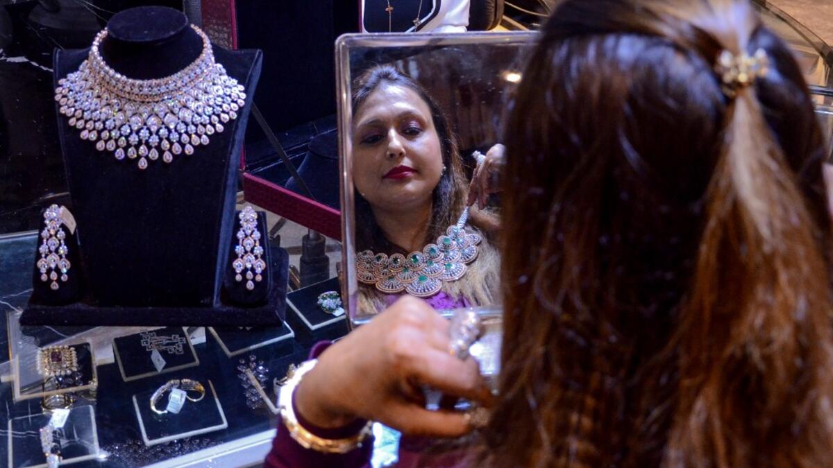 A customer tries on gold jewellery at a store in Amritsar on October 25, 2019. Dhanteras, the first day to mark the Hindu festival of Diwali, is seen as an auspicious day on which to make purchases. NARINDER NANU / AFP