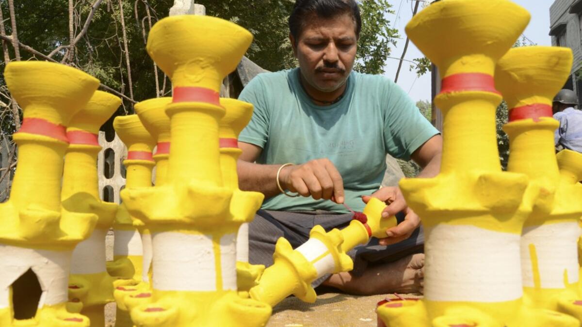 A craftsman paints earthen lamps ahead of the Hindu festival of Diwali in Amritsar on October 25, 2019.  NARINDER NANU / AFP