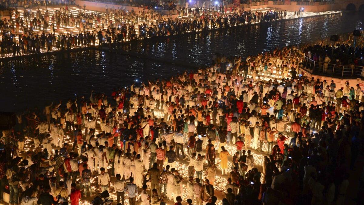 Hindu devotees light earthen lamps on the banks of the River Sarayu on the eve of "Diwali" festival during an event organised by the Uttar Pradesh government, in Ayodhya on October 26, 2019. "Diwali", the Festival of Lights, marks victory over evil and commemorates the time when Hindu god Lord Rama achieved victory over Ravana and returned to his kingdom Ayodhya. SANJAY KANOJIA / AFP