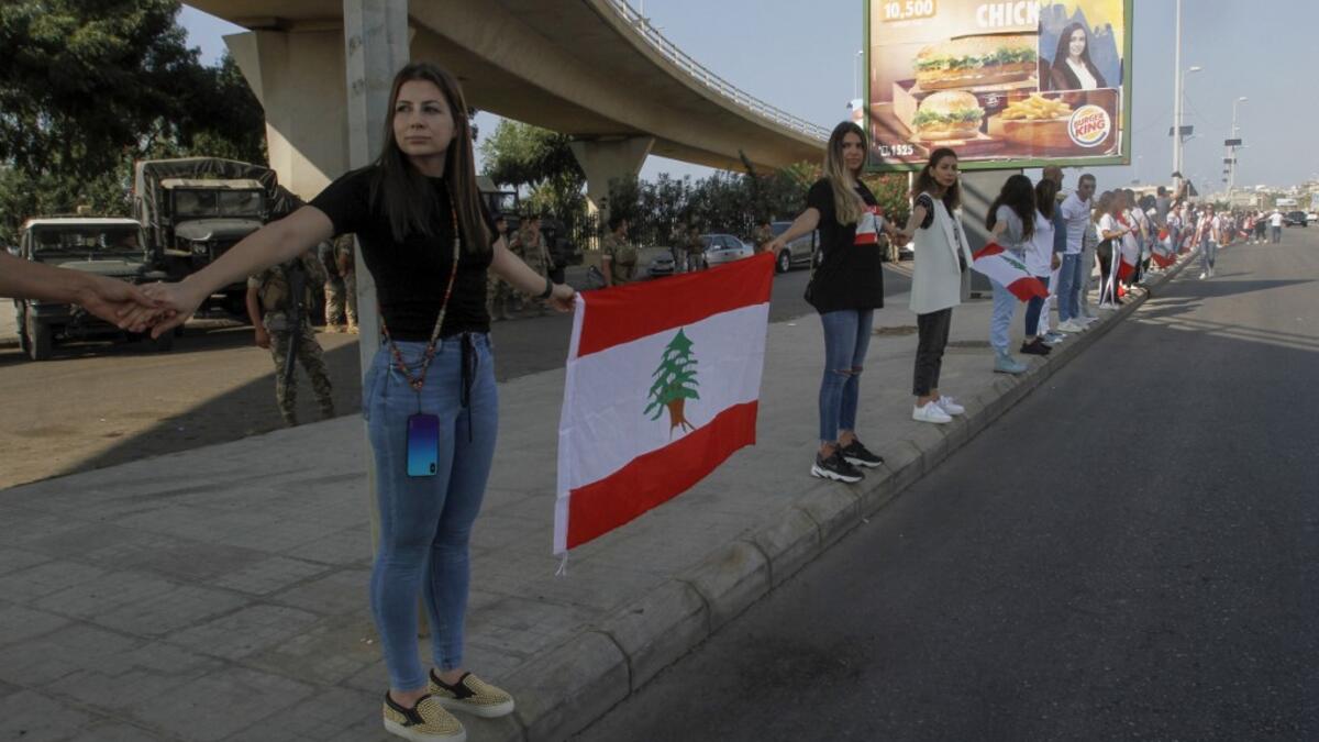 Lebanese protesters hold hands to form a human chain along the coast from north to south as a symbol of unity, during ongoing anti-government demonstrations in the southern Lebanese port city of Sidon on October 27, 2019. Mahmoud ZAYYAT / AFP