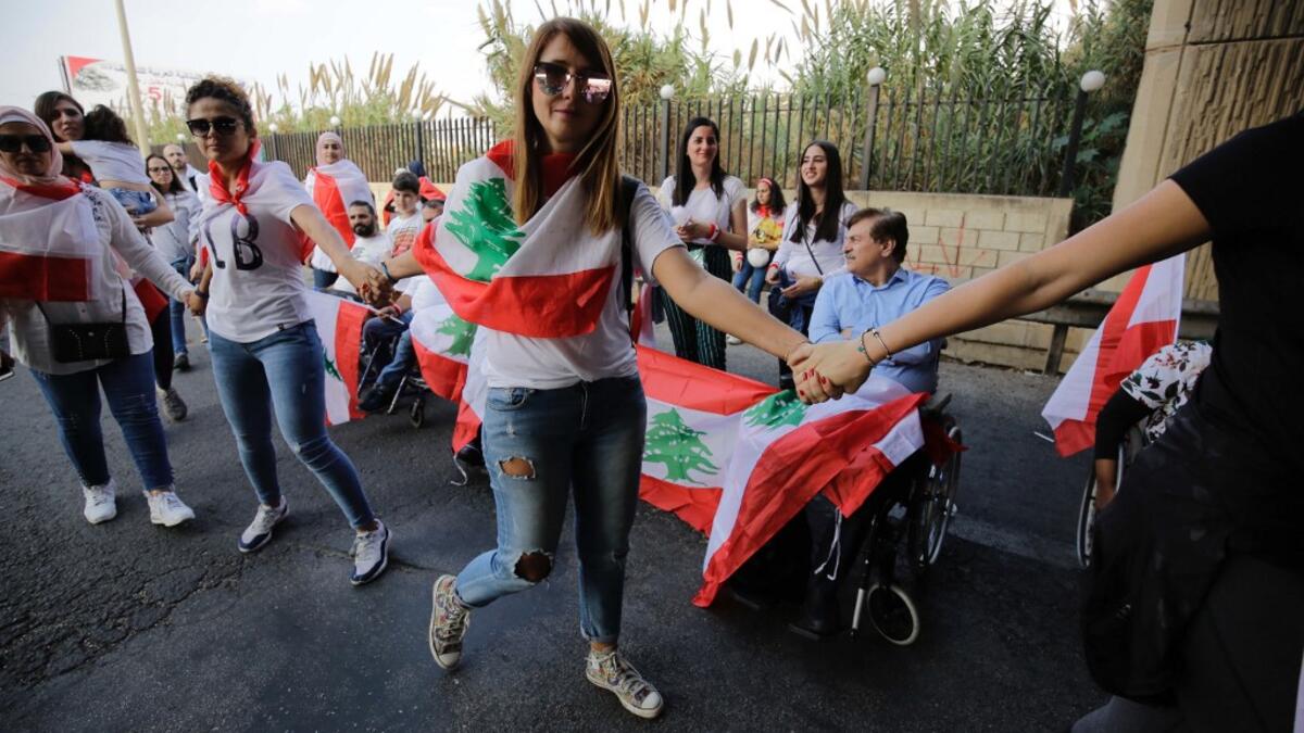 Lebanese protesters hold hands to form a human chain along the coast from north to south as a symbol of unity, during ongoing anti-government demonstrations in Lebanon's northern city of Tripoli on October 27, 2019. Ibrahim CHALHOUB / AFP